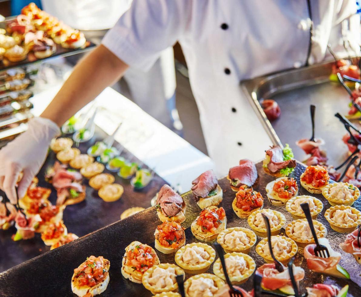 Catering worker placing appetizers on platters