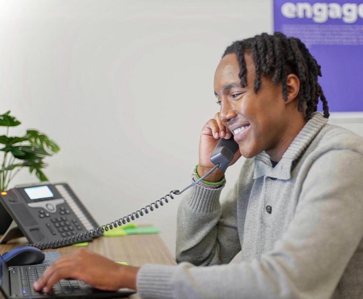 African-American man talking on the phone while working on a laptop