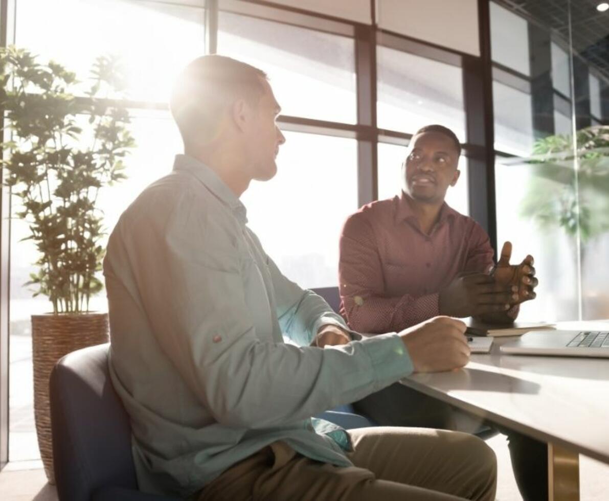 Two businessmen discussing plans in a modern workspace