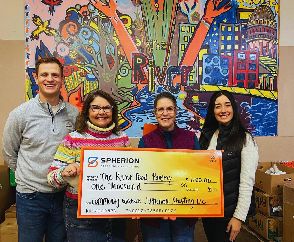 A group of professionals presenting a check to a nonprofit organization
