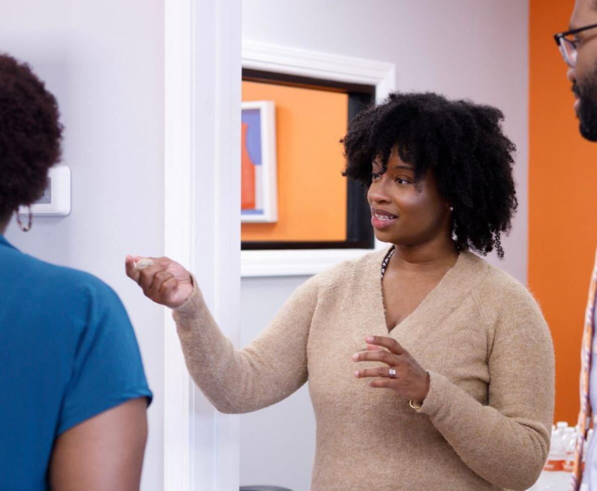 A woman speaking to two others