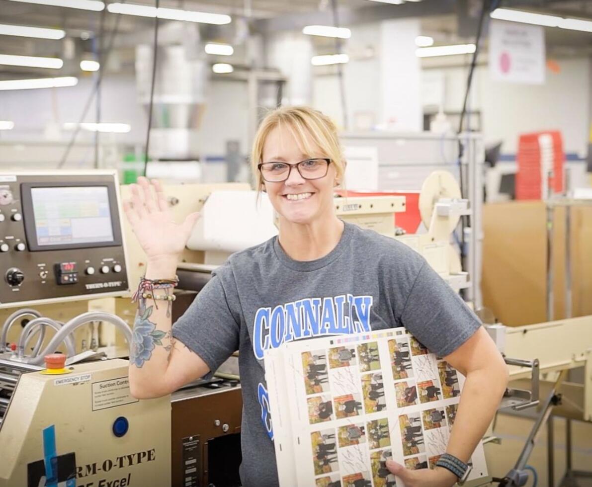 A woman smiling at work in a factory