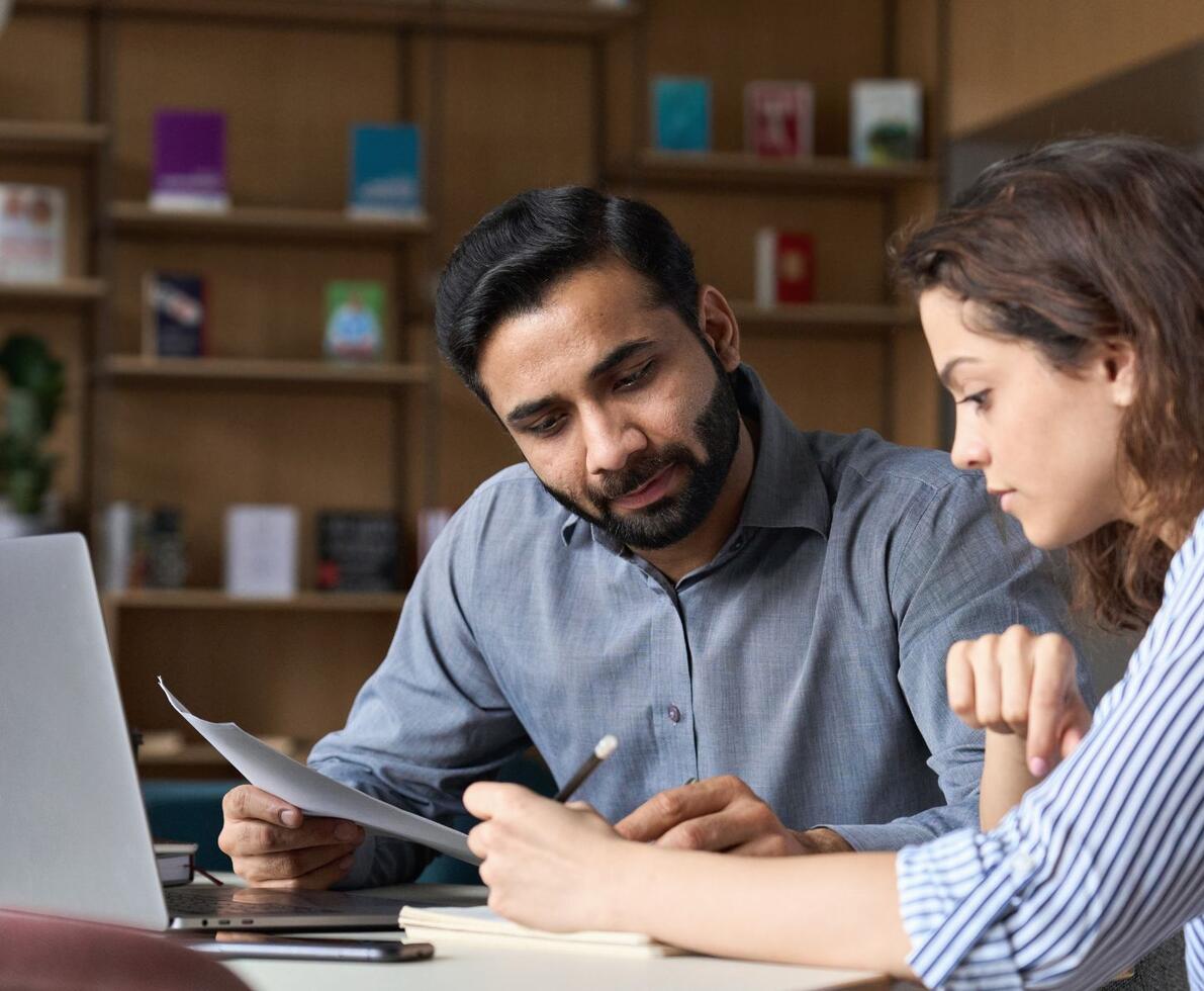 Two business people talking around a laptop