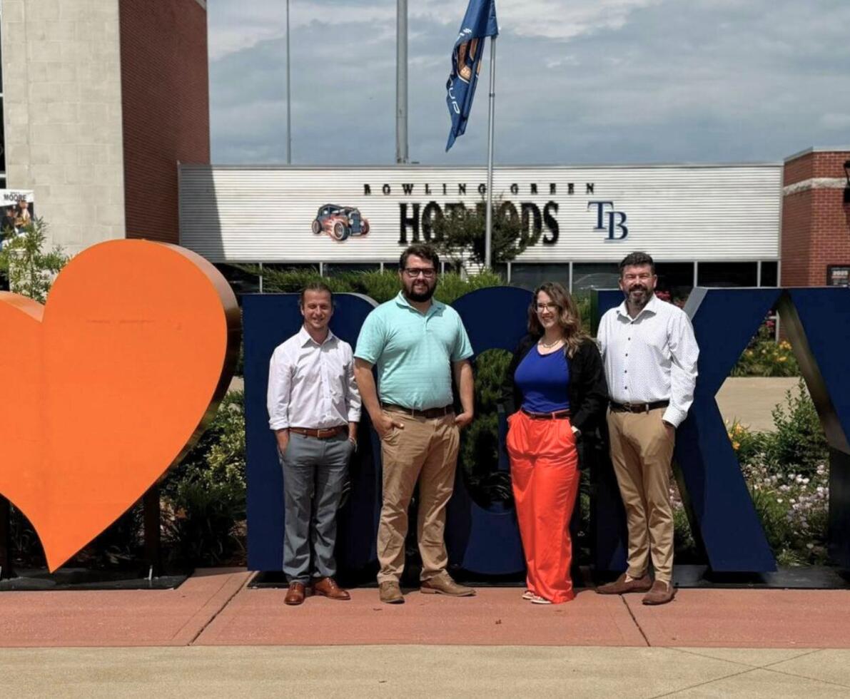 A group of staffing professioanls outside in front of a Bowling Green display