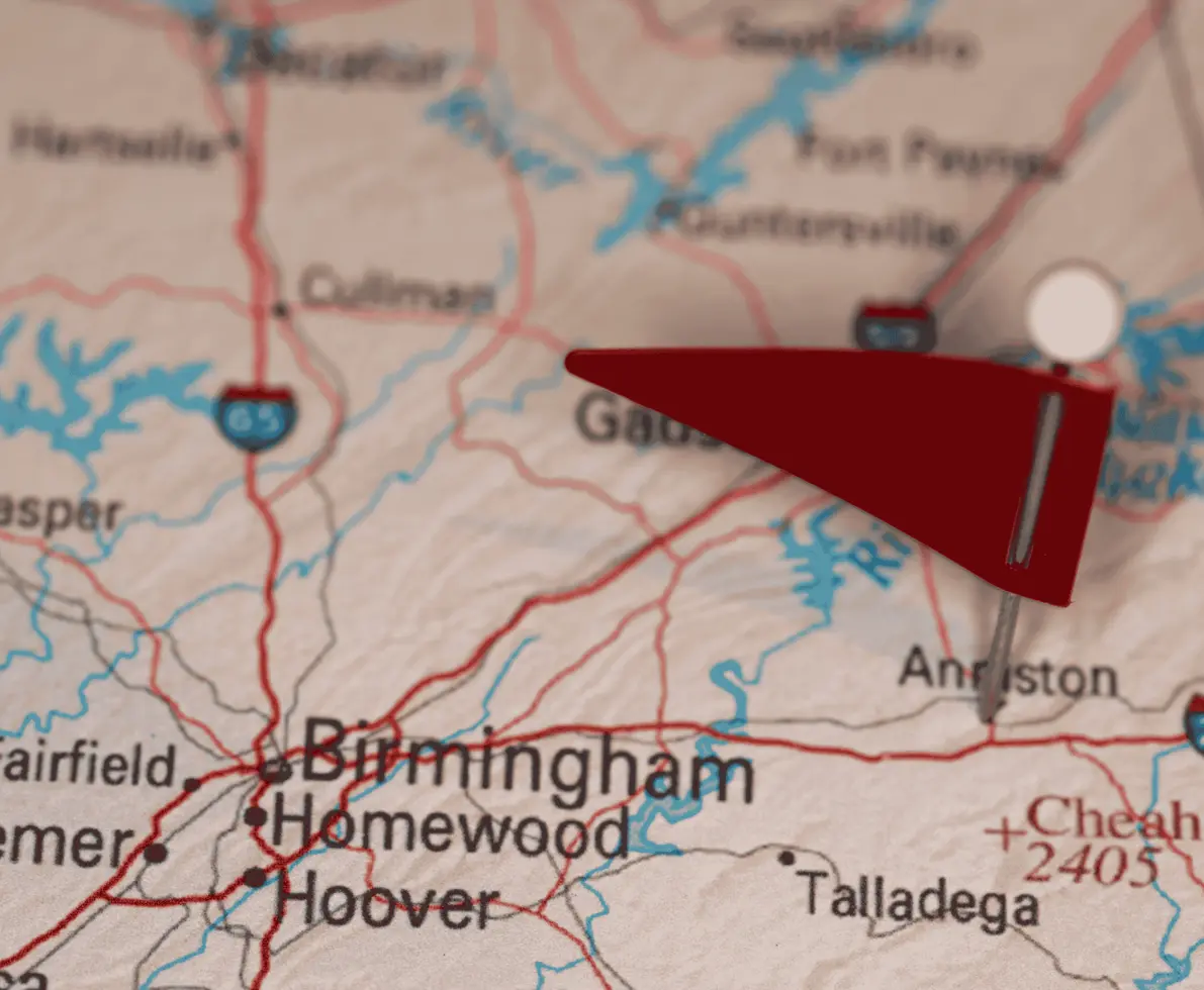 Picture of a map of Alabama with a red flag pinned to Anniston