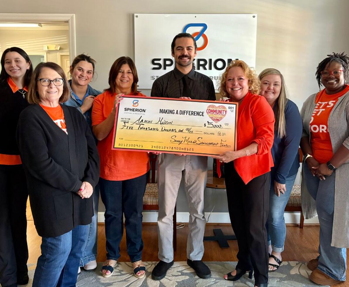 A group of people celebrating a scholarship check