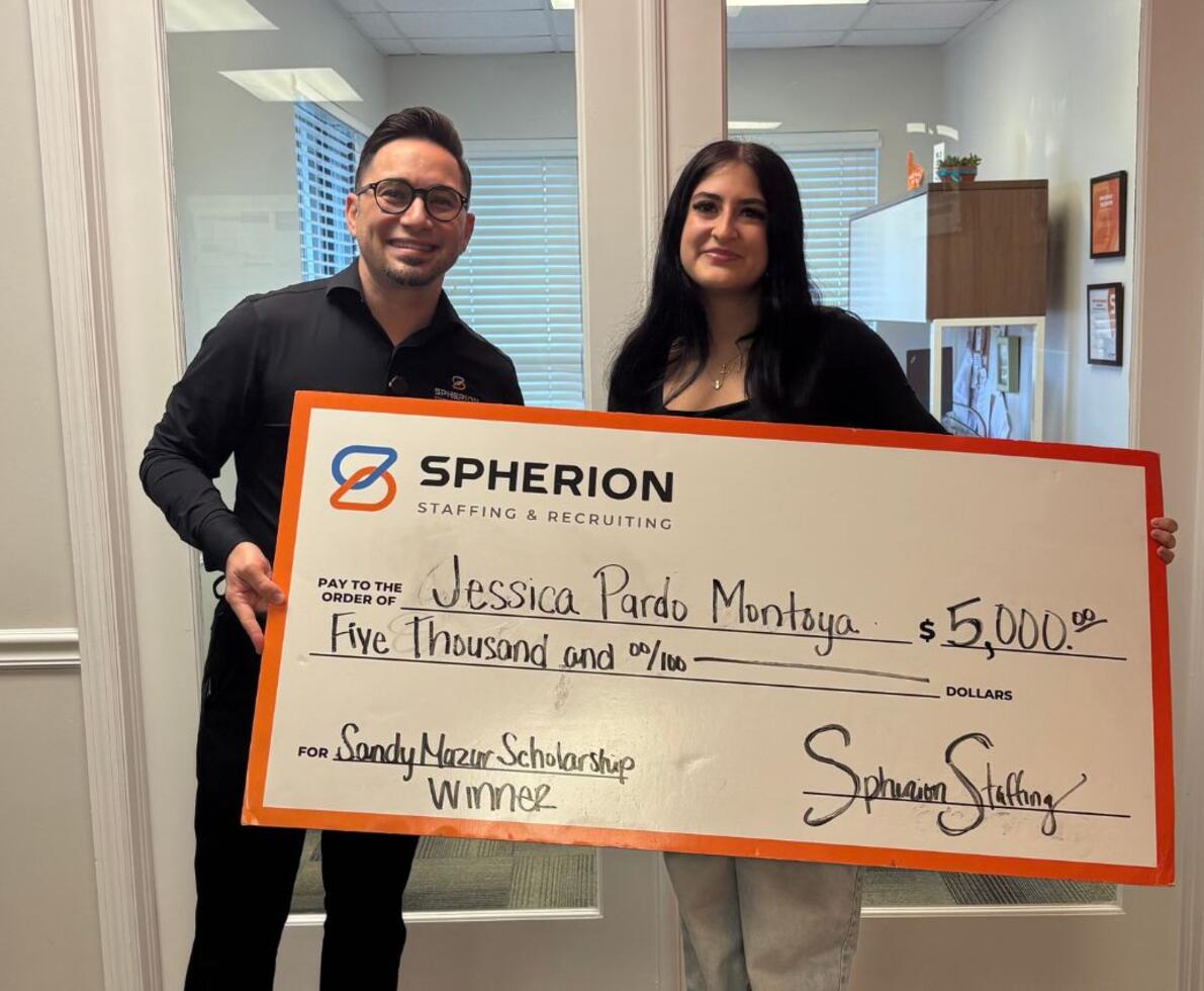 Two people celebrating a scholarship check