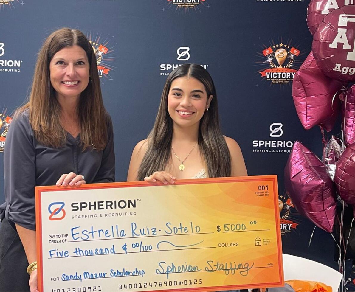 Two women celebrating the awarding of a scholarship check