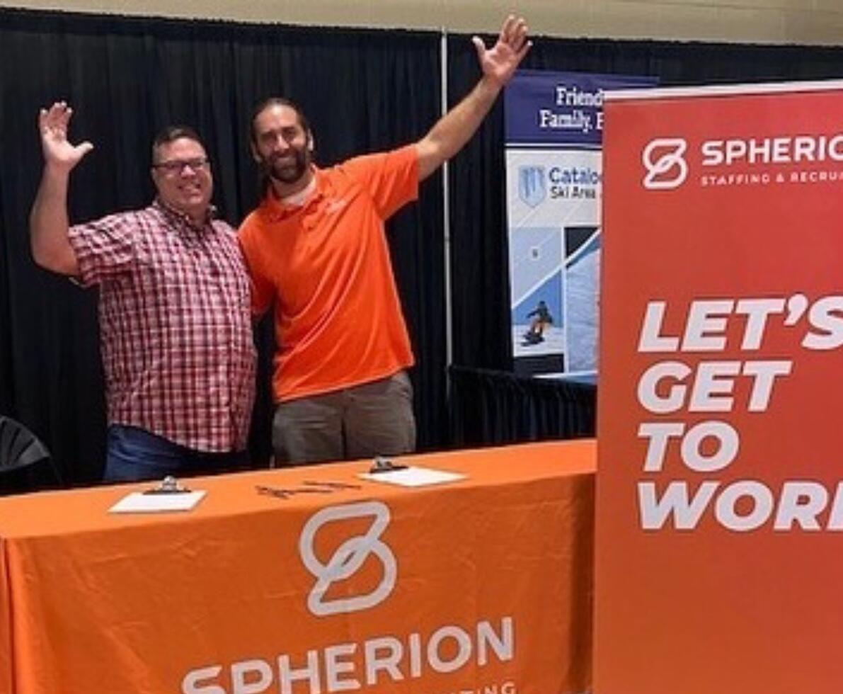 Two men celebrating at a job fair
