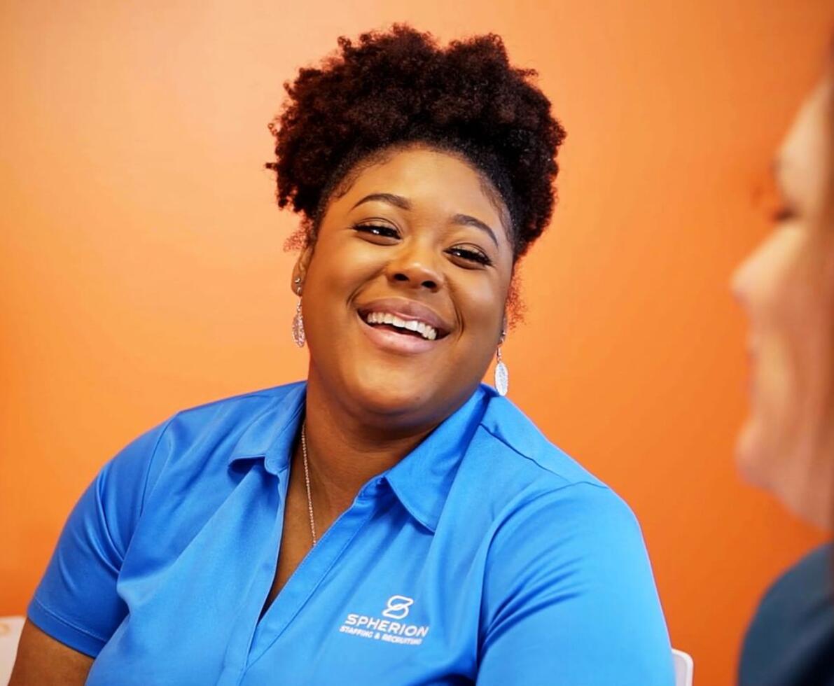 An African-American woman smiling at a colleague