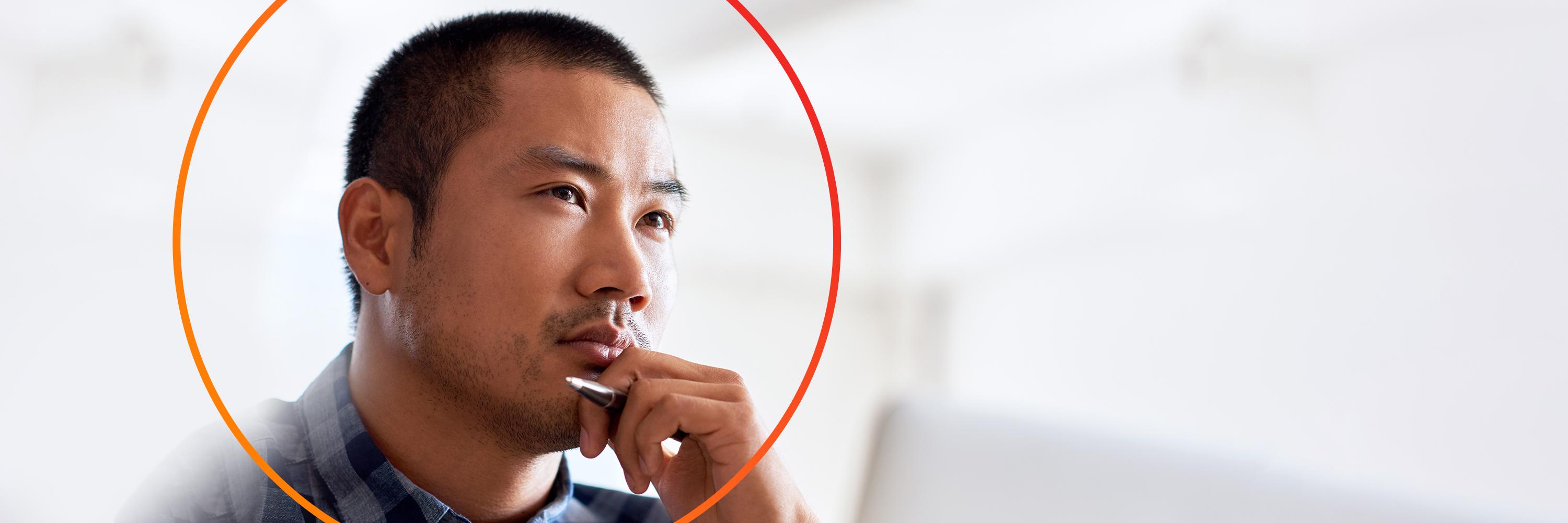 Asian male in thinking pose with orange circle