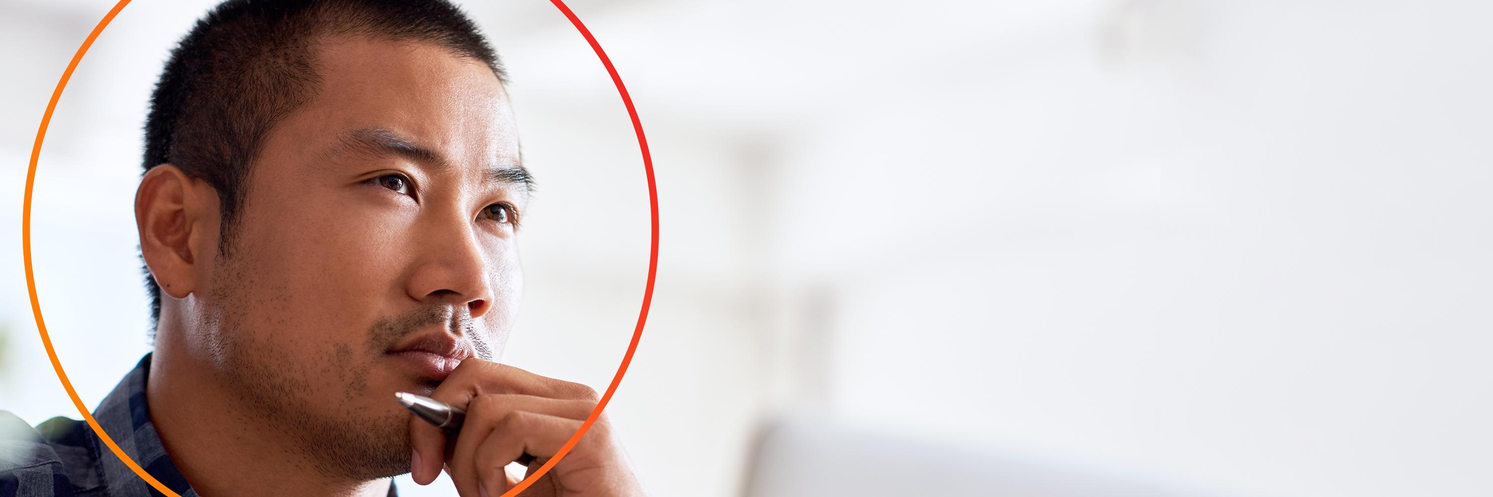 Asian male in thinking pose with orange circle, close up