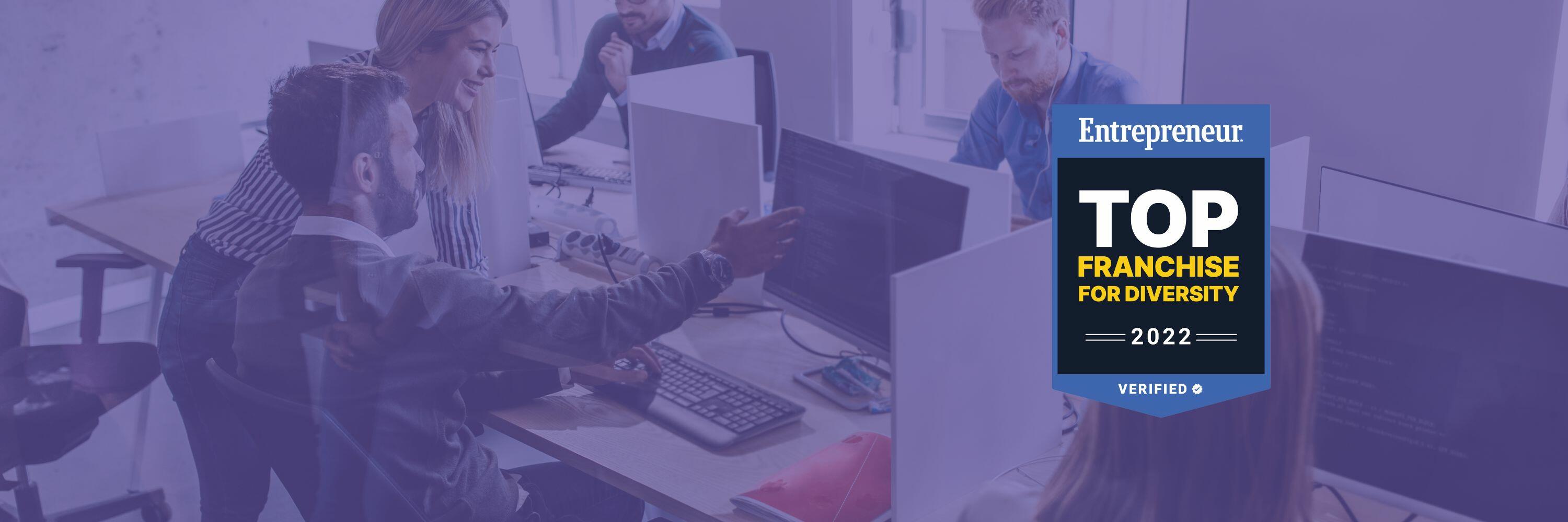 A group of programmers doing work on desktop computers with the blue and black Entrepreneur  Top Franchise for Diversity 2022 logo on the right