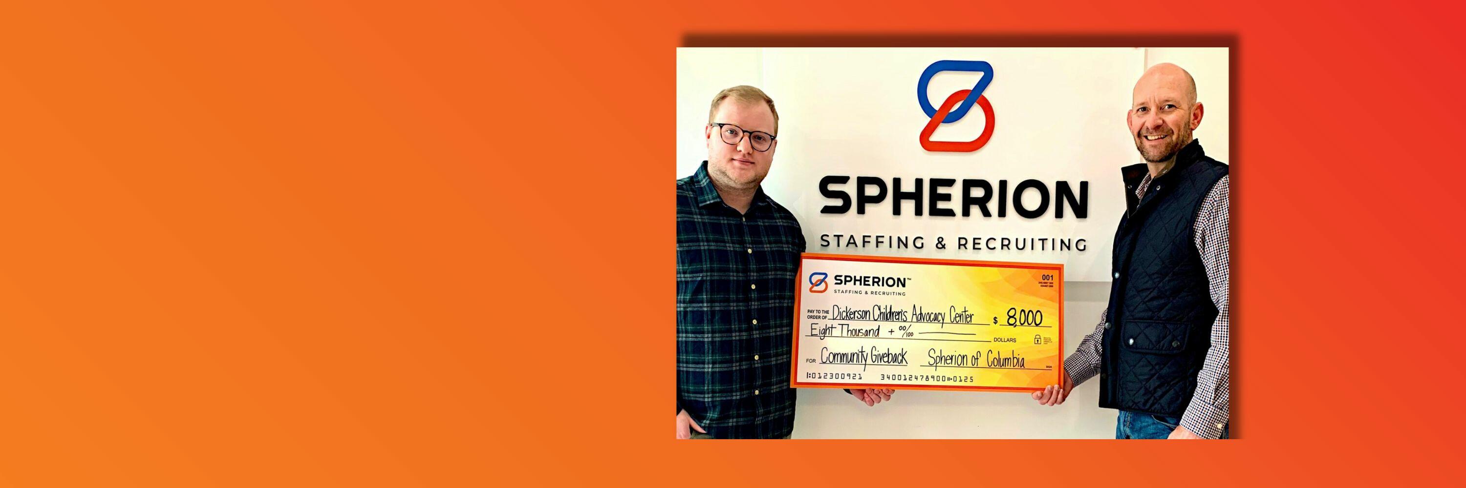 Orange background with a photo of two men smiling and holding a giant check