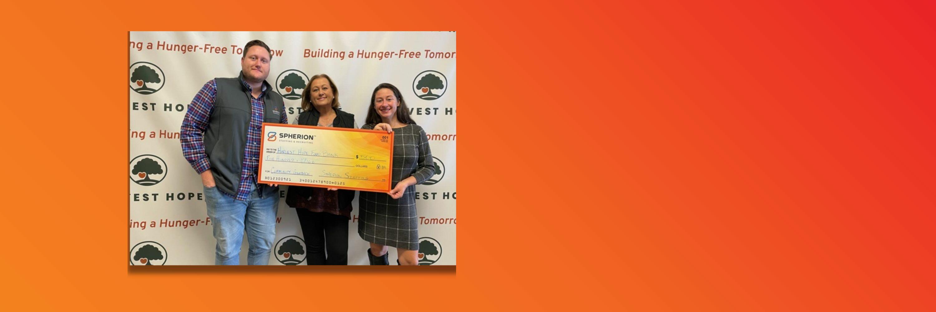Orange background with a photo of three people holding a giant check