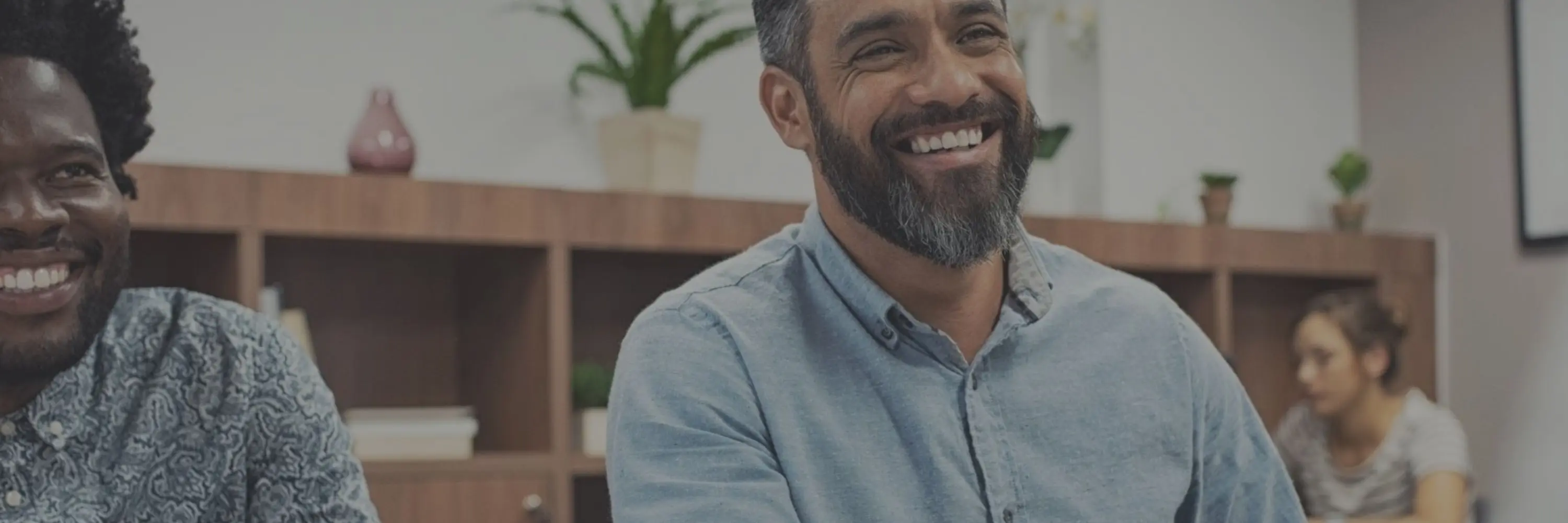A smiling man shaking hands in an office setting