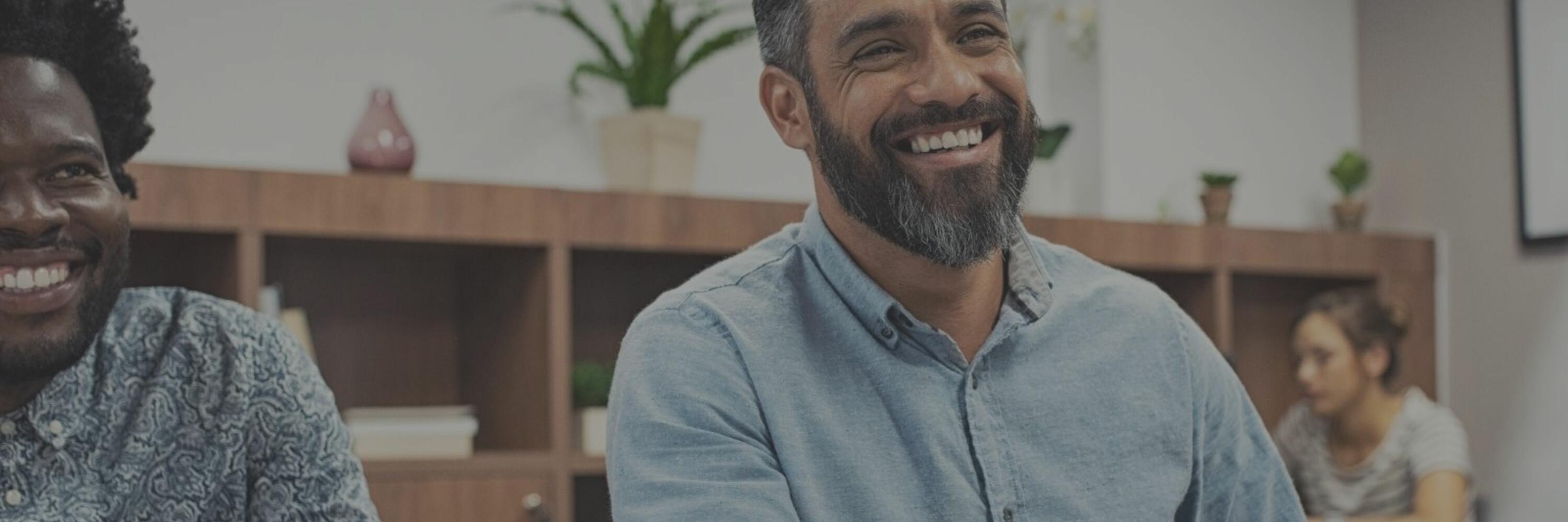 A smiling man shaking hands in an office setting