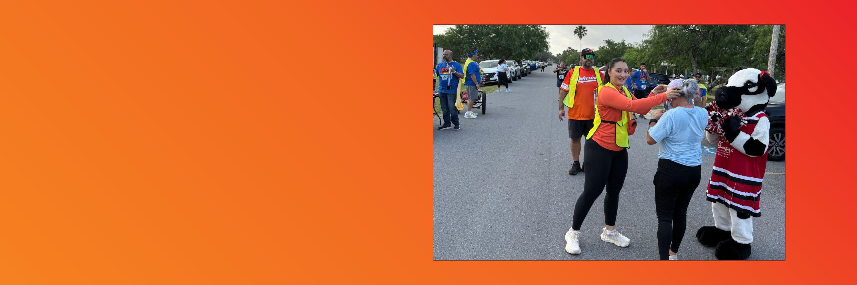 An orange background with a photo of a woman giving a runner a medal