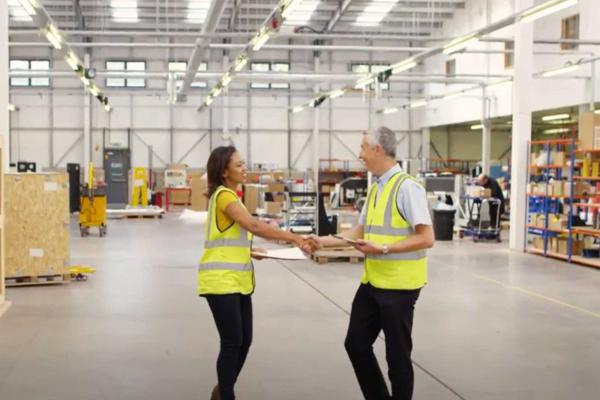 Woman and man shaking hands in a warehouse