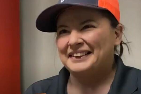 Close-up image of a woman in a baseball hat smiling