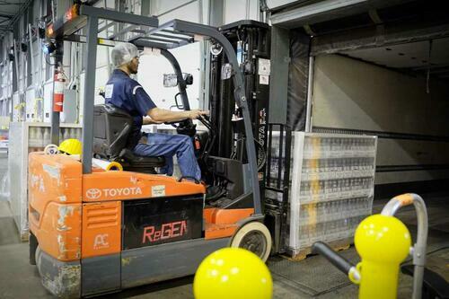 Forklift driver on orange forklift at food production factory