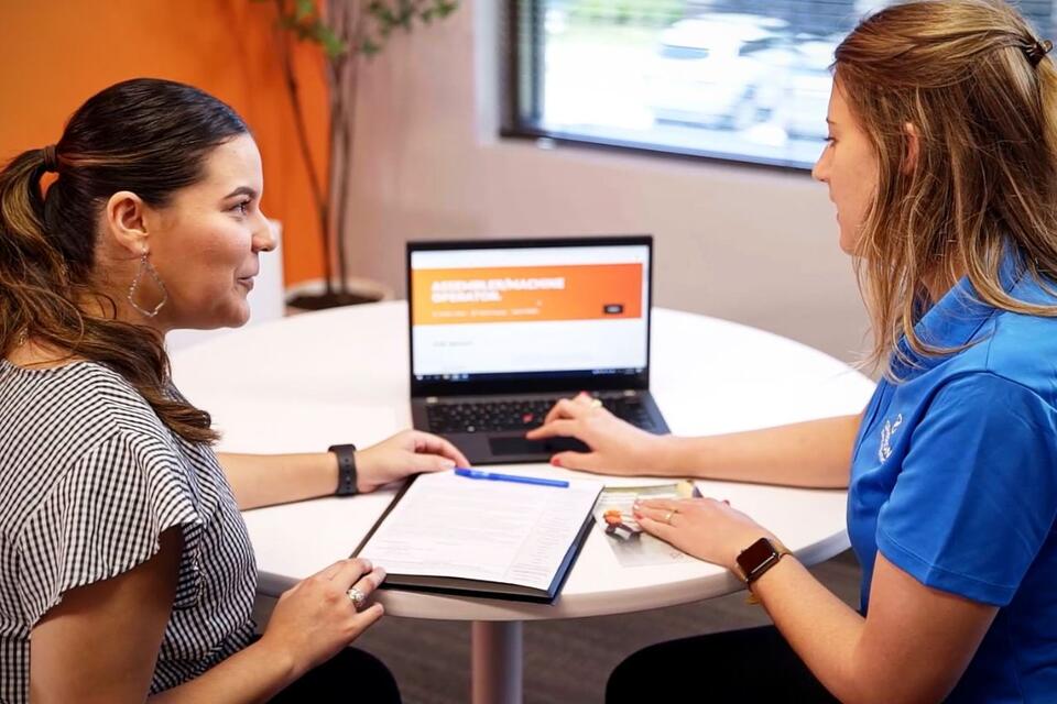 Two women discussing a job posting