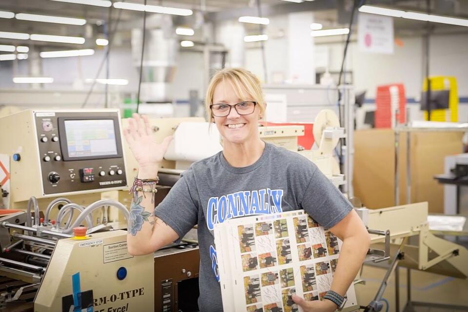 A woman smiling at work in a factory