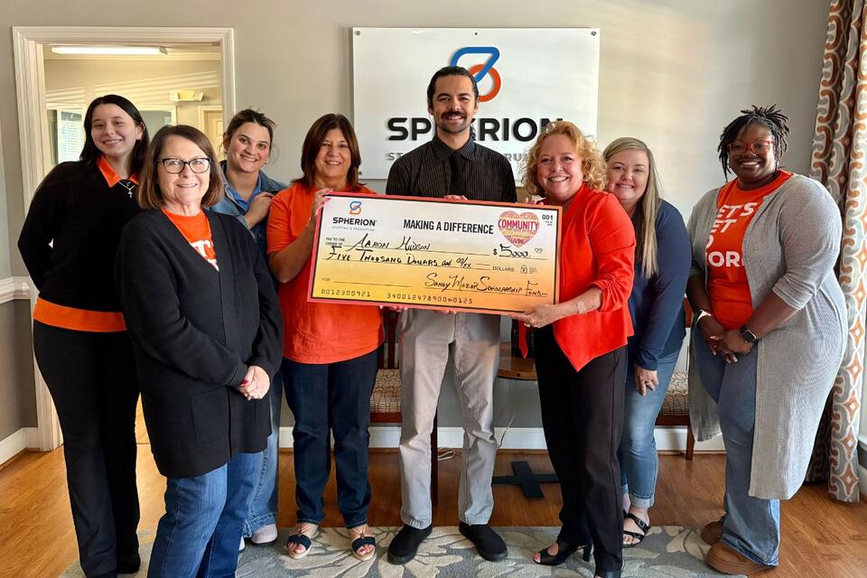 A group of people celebrating a scholarship check
