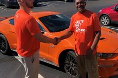 Spherion Works Sweepstakes Winner Michael P. shaking hands with Scott after receiving his new orange Ford Mustang GT