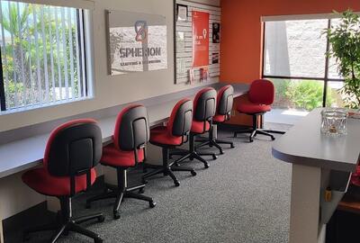 Photo of an office interior with six chairs pulled up to a counter