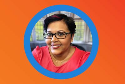 Orange background with a blue circular frame in the enter featuring a picture of a smiling Black professional woman in glasses.